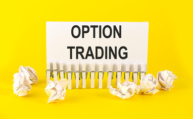 text OPTION TRADING . on the white short note paper on yellow background