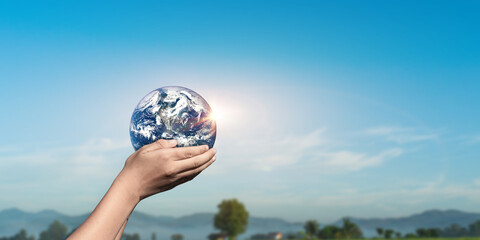 Hands holding Globe, Earth on nature sky background. Elements of this image furnished by NASA