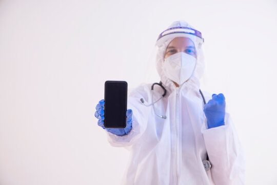 A Health Worker In PPE Kit Holding A Mobile Phone.