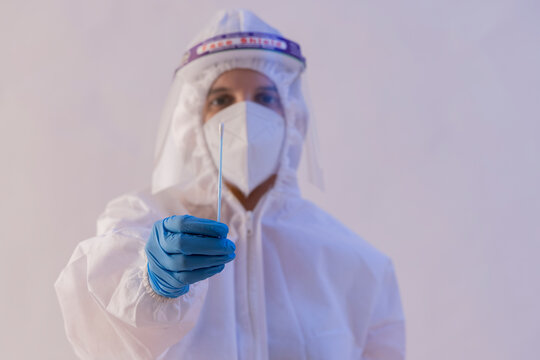 A Health Worker In PPE Kit Holding A Cotton Swab.