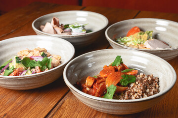 Buckwheat porridge with fish in a ceramic plate over rustic wooden background.
