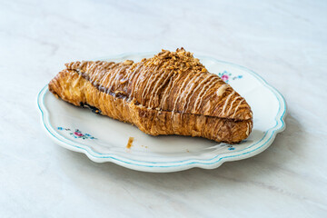 Freshly Baked Crispy Croissant with Cinnamon Cream and Hazelnut Powder.