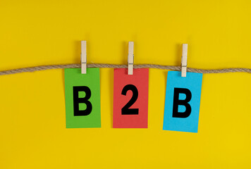 B2B an acronym for Business to Business letters on coloured paper attached to a string with cloth pegs.