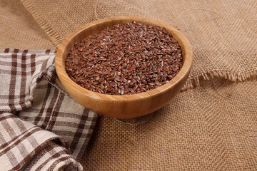 Flex seed flaxseed in wooden bowl on jute fabric cloths