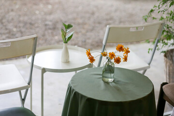 selective focus reusable old clear glass bottle Used to decorate the shop, put water, make a vase, put yellow flowers in a small coffee shop. Decorate the shop with antiques. day without customers
