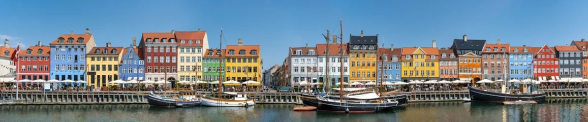 Papier Peint photo autocollant Navire Vue panoramique sur Nyhawn, les maisons colorées à côté du vieux port. Touriste visitant des restaurants, des cafés et des navires dans le canal. Le site touristique le plus important de Copenhague, au Danemark.