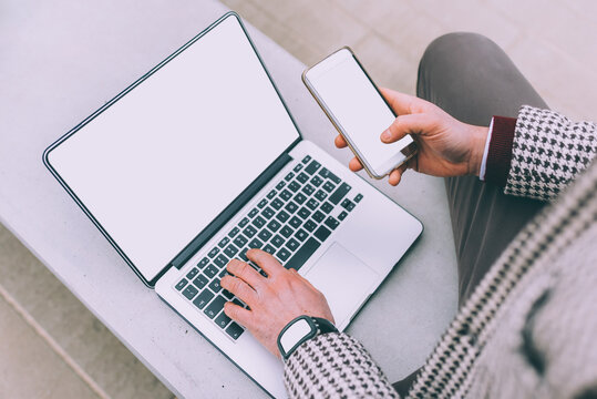 Unrecognizable business man outdoor multitasking using computer, smartphone and smartwatch with blank copyspace screen