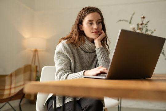 Young woman watching media or video conferencing on laptop