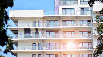 Modern white facade of a residential building with large windows. View of modern designed concrete apartment building.