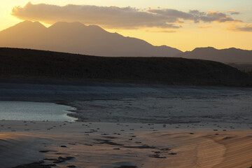 Fototapeta premium Dried lake on summer. Water crisis and drought impact case or climate change. Low tide lake. Withdrawal of dam water as a result of global warming. Declining water dams and lake. Sunset. Cloudy sky
