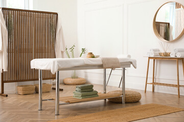 Stylish room interior with massage table in spa salon