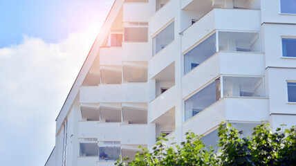 Modern white facade of a residential building with large windows. View of modern designed concrete...