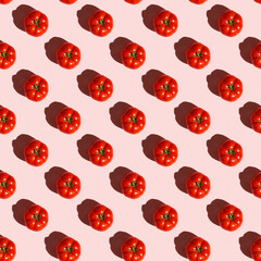 Red tomatoes pattern on a pastel pink background, flat lay. Tomato wallpaper, vegetable pattern, pop art composition.Top view.