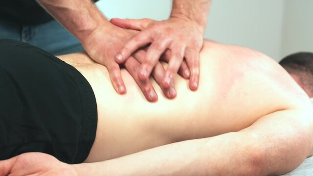 Close up footage of physiotherapist man making massage on back 