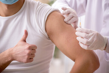 Young male patient visiting old male doctor in vaccination conce
