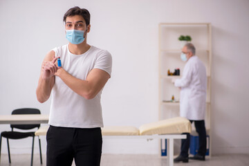 Young male patient visiting old male doctor in vaccination conce