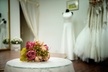 Wedding bouquet of roses flowers on table with lace at wedding saloon near white dress