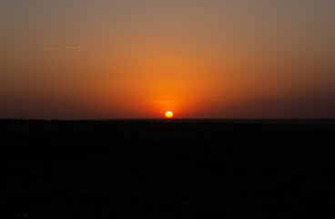Fototapeta premium Sunset over a meadow, wild steppe, in the summer season. Scenery