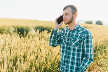 Farmer talking on mobile phone in the field on a sunny day