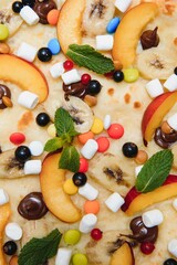 Sweet pizza with marshmallow sauce and colored sweets, chocolate pizza with colored sweets and chocolate pizza with banana on a white background