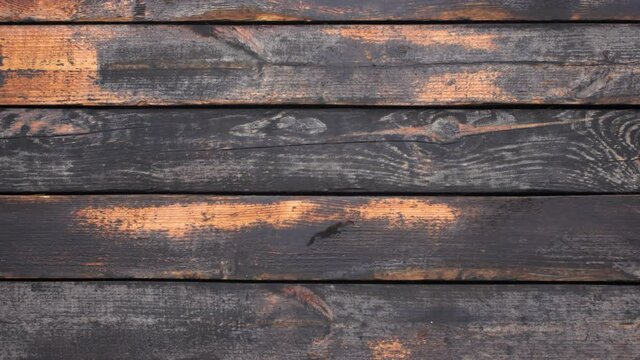 Close-up top view flatlay 4k stock video footage of old used vintage tool. Man puts old rusty saw on weathered wooden surface background