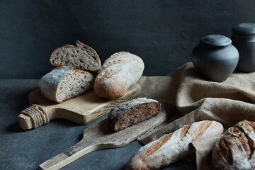 horizontal still life photo on black background. The photo shows different types of bread and black...