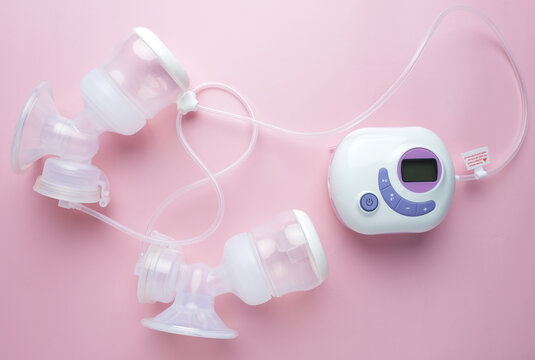 A picture of portable lactation breast pump on pink background.