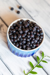Blueberries in a blue cup on a white shabby table. Selective focus