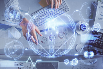 Double exposure of man's hands typing over computer keyboard and science theme hologram drawing. Top view. Education concept.