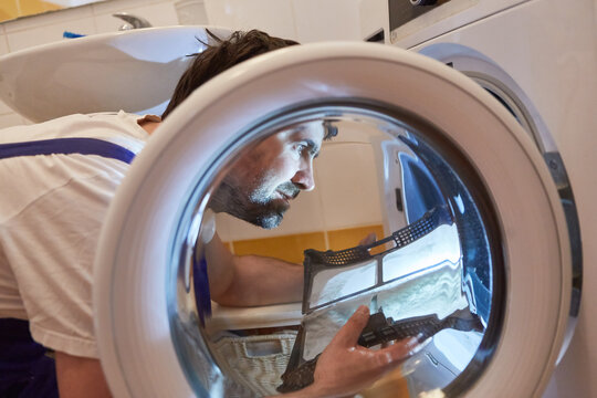 Handwerker beim S&auml;ubern vom Flusensieb