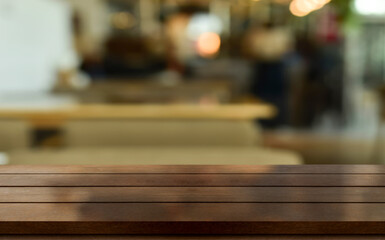 Empty wooden table top with lights bokeh on blur restaurant background.