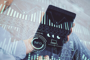 Double exposure of man's hands holding and using a digital device and tech theme hologram drawing....