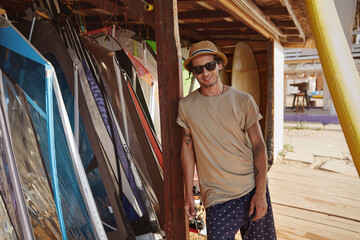 Fototapeta premium Man stand on wooden platform with surf equipment