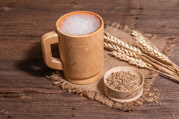 Beer and grain. Oktoberfest concept, wooden mugs on old table