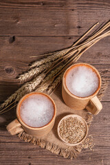 Beer and grain. Oktoberfest concept, wooden mugs on old table