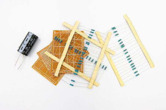 DIY Electronic Parts including capacitor, resistor, and perfboard isolated on white background