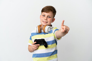 Little redhead boy holding a game pad isolated on white background showing and lifting a finger