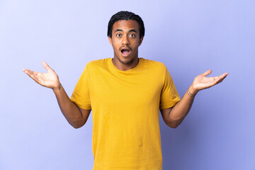 Young African American man with braids man isolated on purple background with shocked facial expression