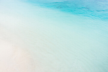 Fototapeta na wymiar White sandy beach with transparent gradient blue water