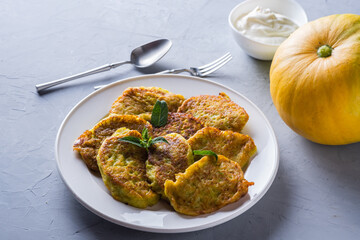 Vegetable veggie pumpkin pancakes with sour cream, summer food, delicious snacks. Pumpkin pancakes. Healthy food concept