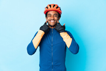 Young cyclist man with braids over isolated background smiling with a happy and pleasant expression