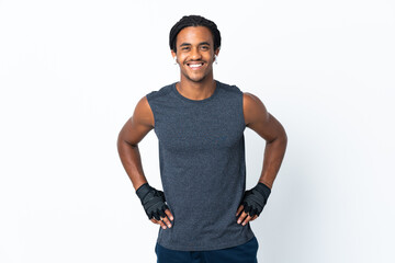 Young African American man with braids isolated on purple background posing with arms at hip and smiling