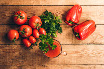 Red pepper and fresh tomatoes on a wooden table. Tomato juice with salt.