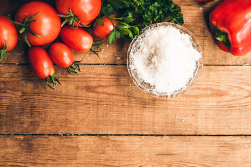 Red pepper and fresh tomatoes on a wooden table. Tomato juice with salt.