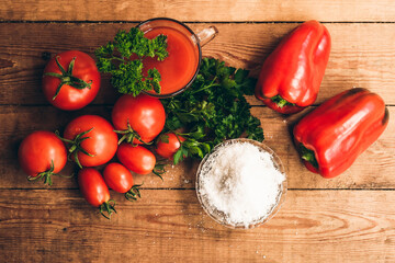 Red pepper and fresh tomatoes on a wooden table. Tomato juice with salt.