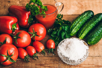 Red pepper and fresh tomatoes and pickles on a wooden table.