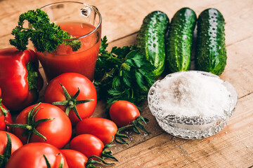 Red pepper and fresh tomatoes and pickles on a wooden table.