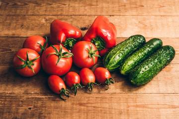 Red pepper and fresh tomatoes and pickles on a wooden table.