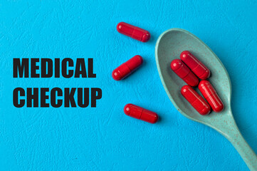 Red pill capsules on blue background with text MEDICAL CHECKUP