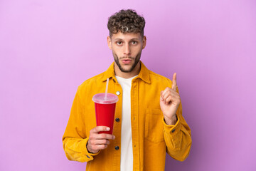 Young blonde man holding soda isolated on purple background intending to realizes the solution while lifting a finger up